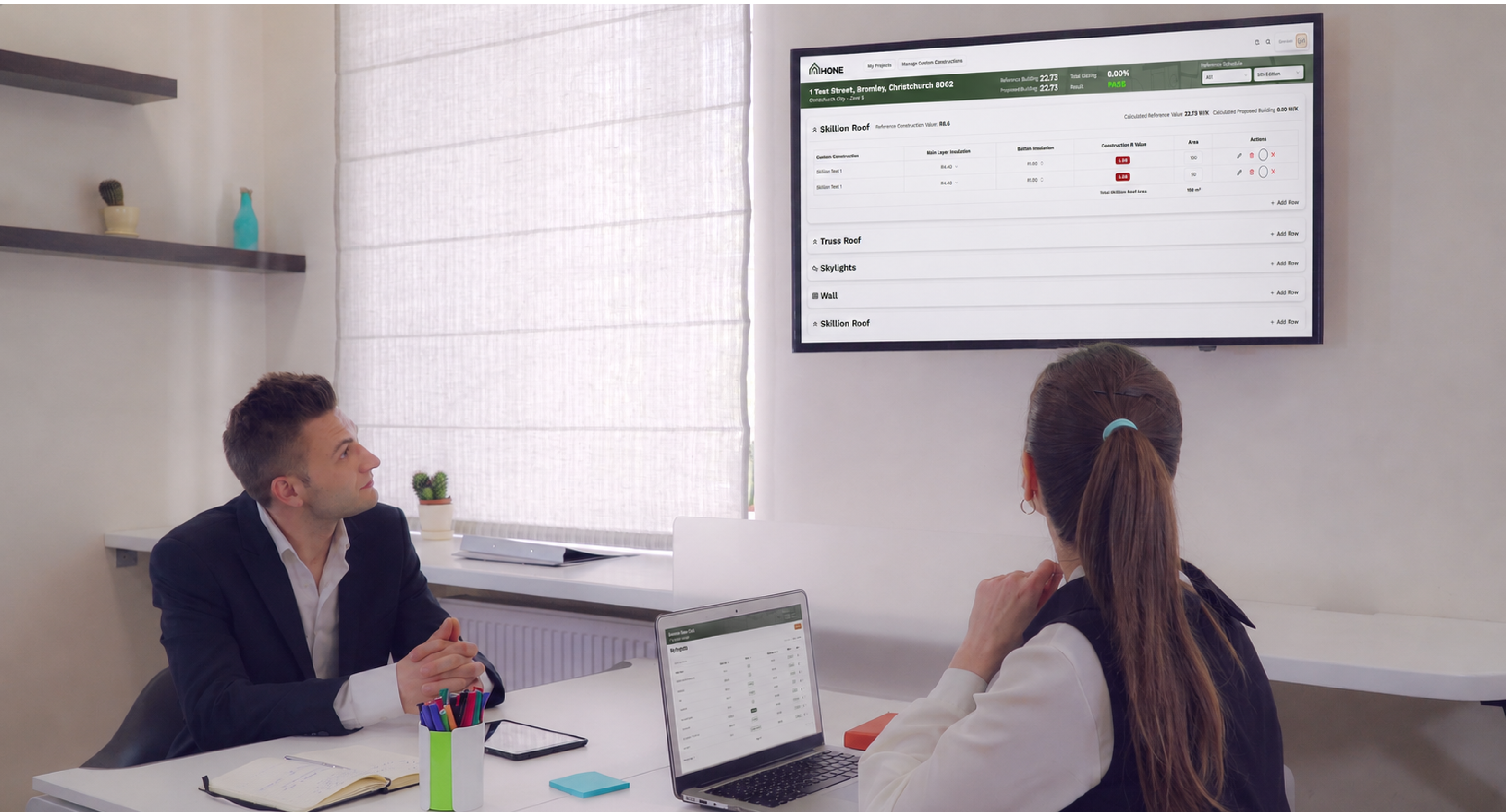 Office workers looking at Hone on TV Screen